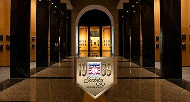 1939 Society logo over an image of the Plaque Gallery at night