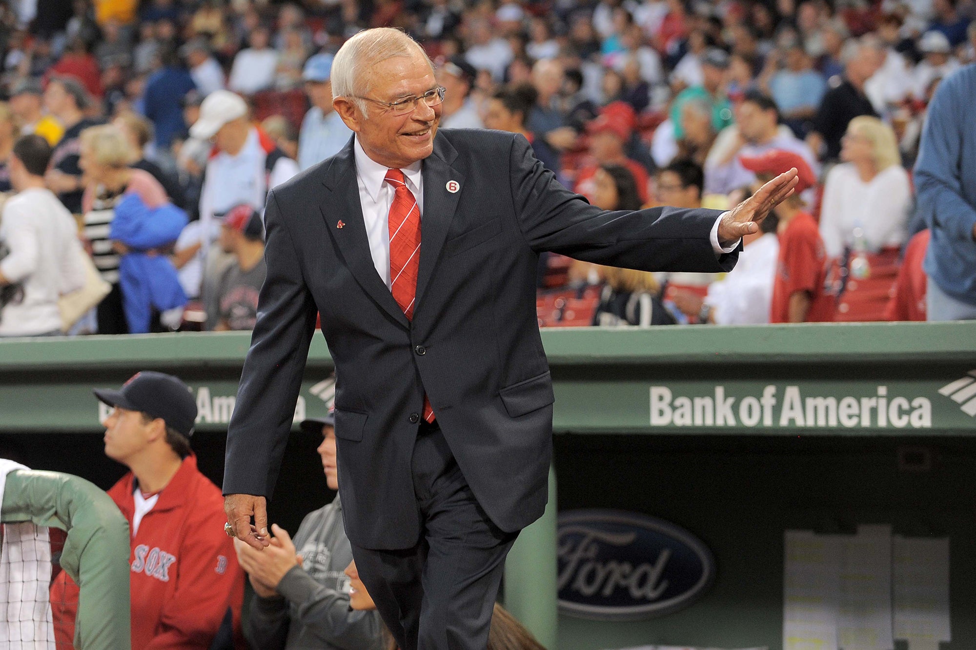 Joe Castiglione waves on field at Fenway Park