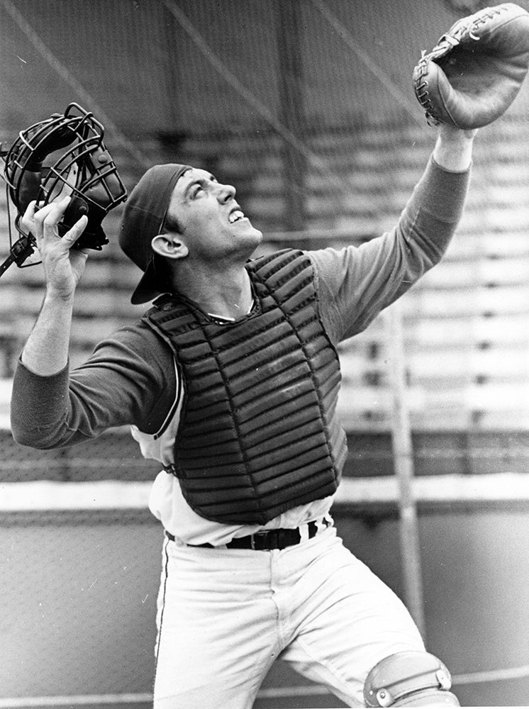 Ray Fosse looks skyward holding catcher's mask