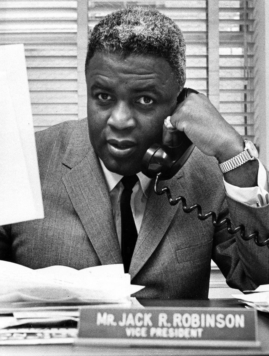 Jackie Robinson speaking on a telephone.