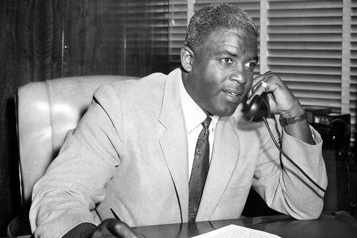 Jackie Robinson at desk speaking on telephone