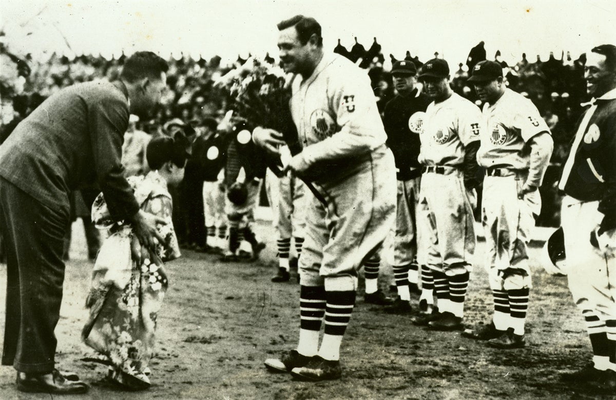 Babe Ruth receiving flowers from a child.