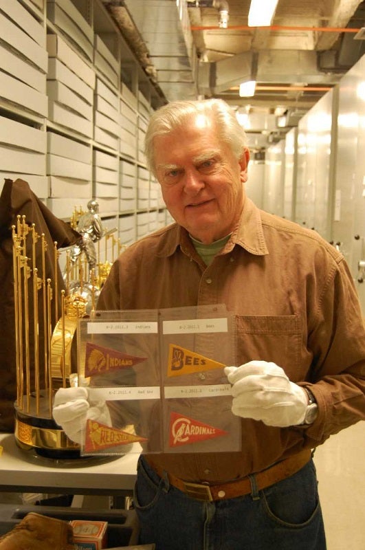 A artifact donor holding hte mini pennats he donated to the Museum. 